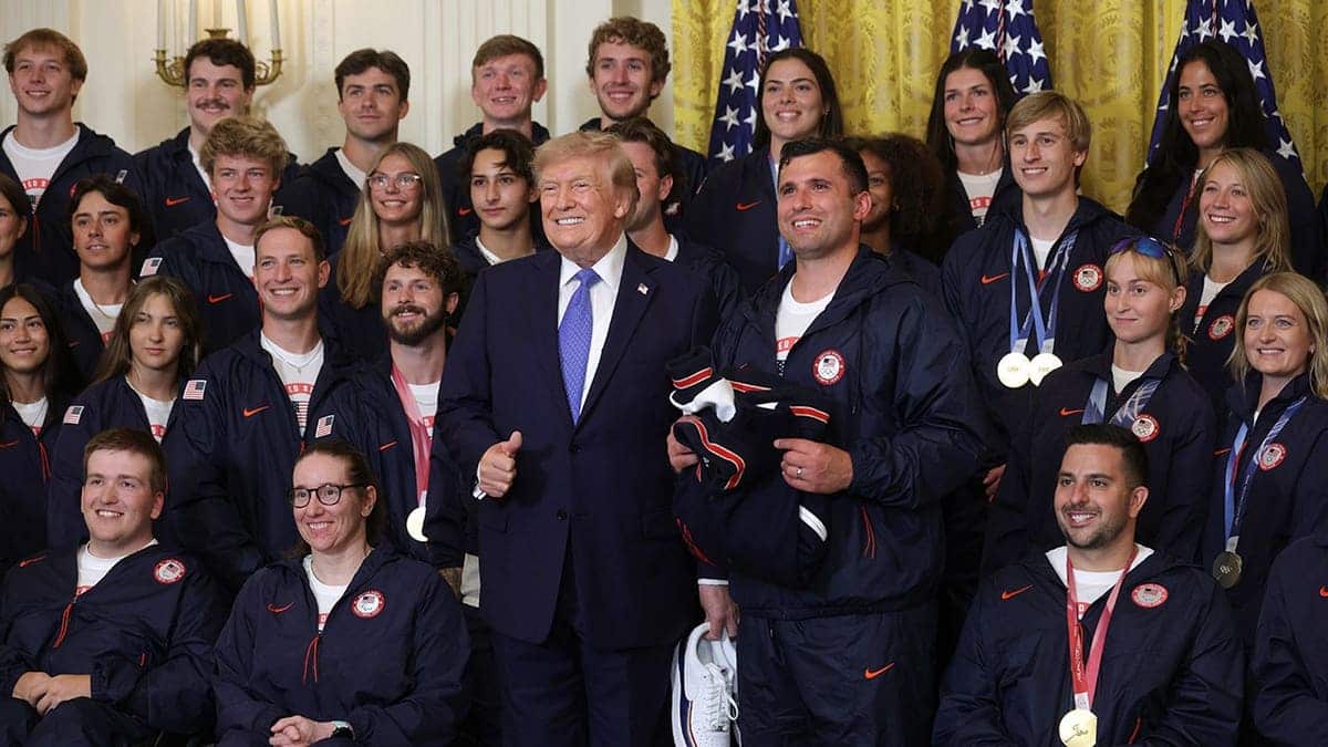 President Donald Trump poses with Olympic medal-winning athletes at the White House.
