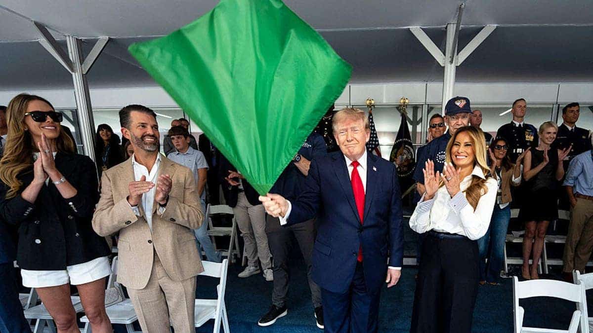 President Donald Trump waves a green flag beside First Lady Melania Trump at the start of a race.