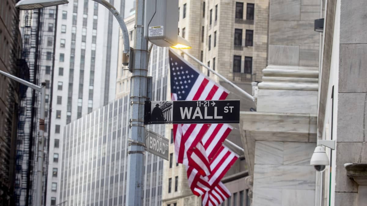 A photo of Wall Street with American flags.