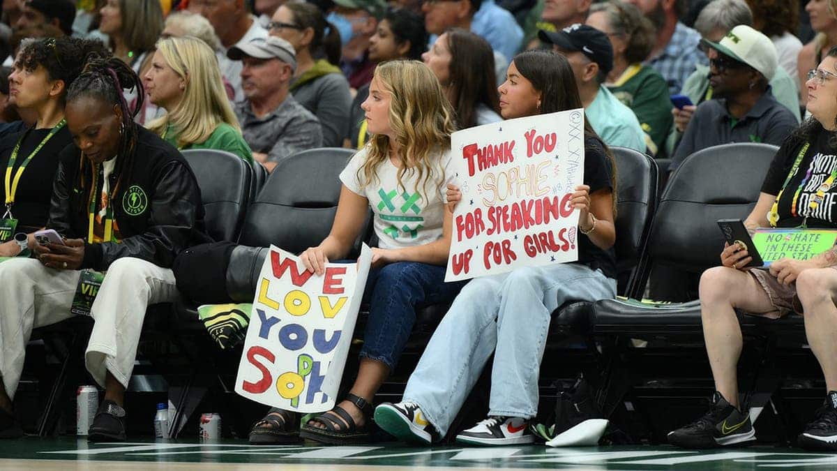 Fans hold a Sophie Cunningham sign during a WNBA game at Climate Pledge Arena.