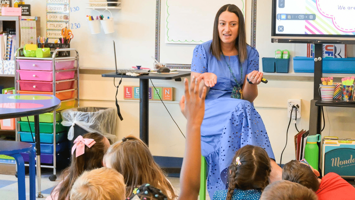 A second grade teacher at Pumpkin Delight School in Milford, Conn., welcomes her class on the first day of school Thursday, Aug. 28, 2025.