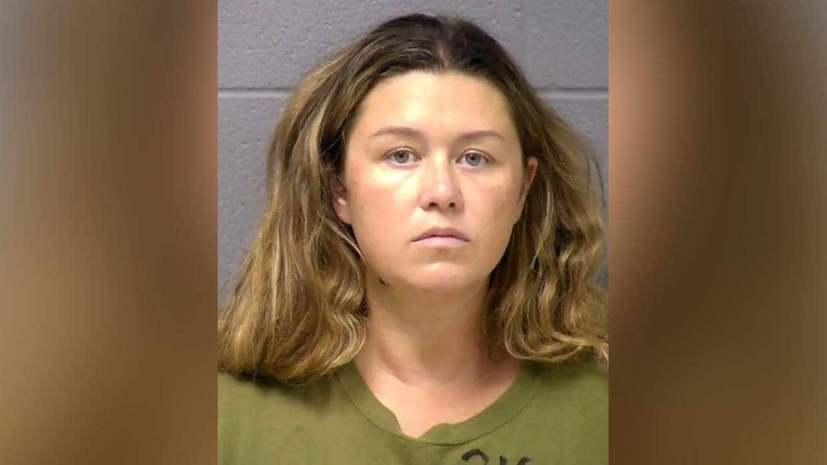 Booking mugshot of Corie A. Walsh facing forward against a gray wall wearing an olive green shirt.