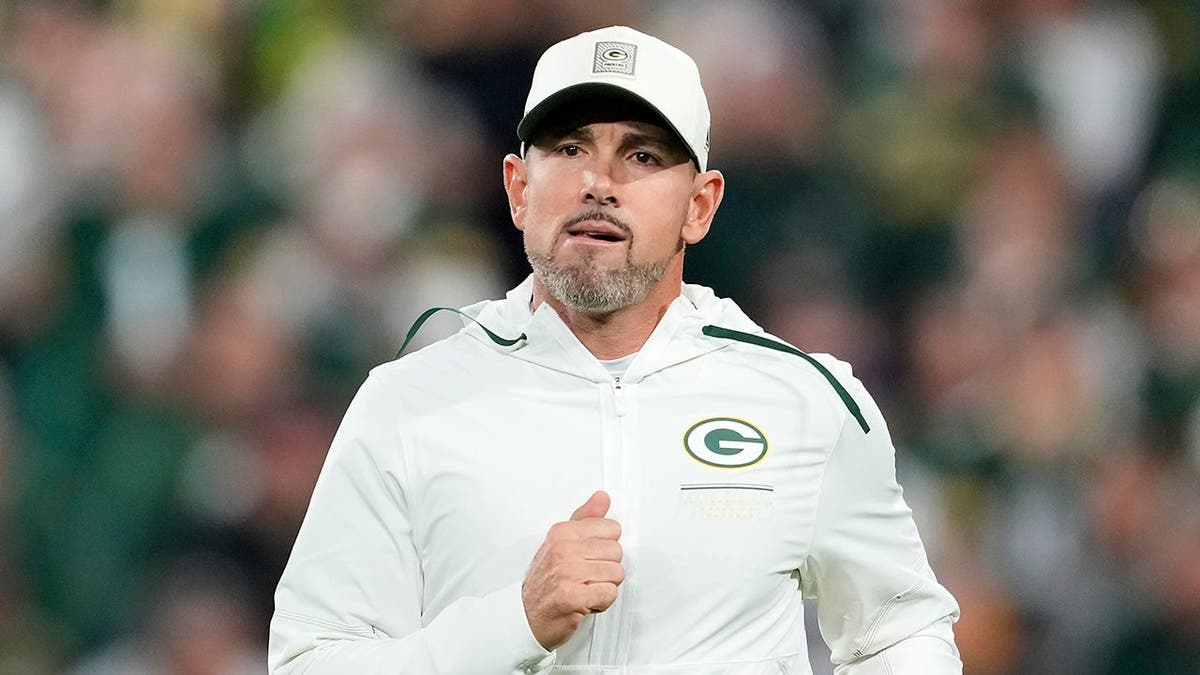 Matt LaFleur walks onto the field before a game at Lambeau Field.