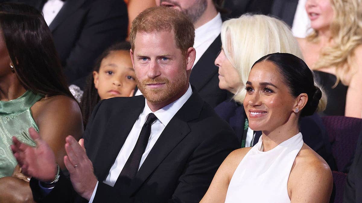 Prince Harry and Meghan Markle sitting together in formal wear at an event in California.