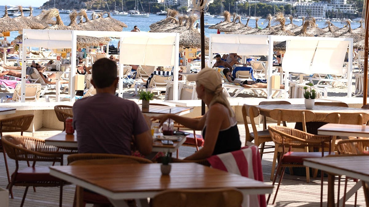Couple sitting on beach in Mallorca