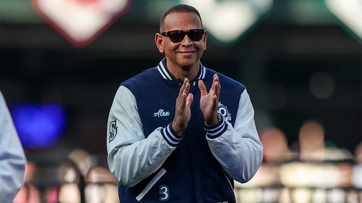 Alex Rodriguez claps while standing on a field.