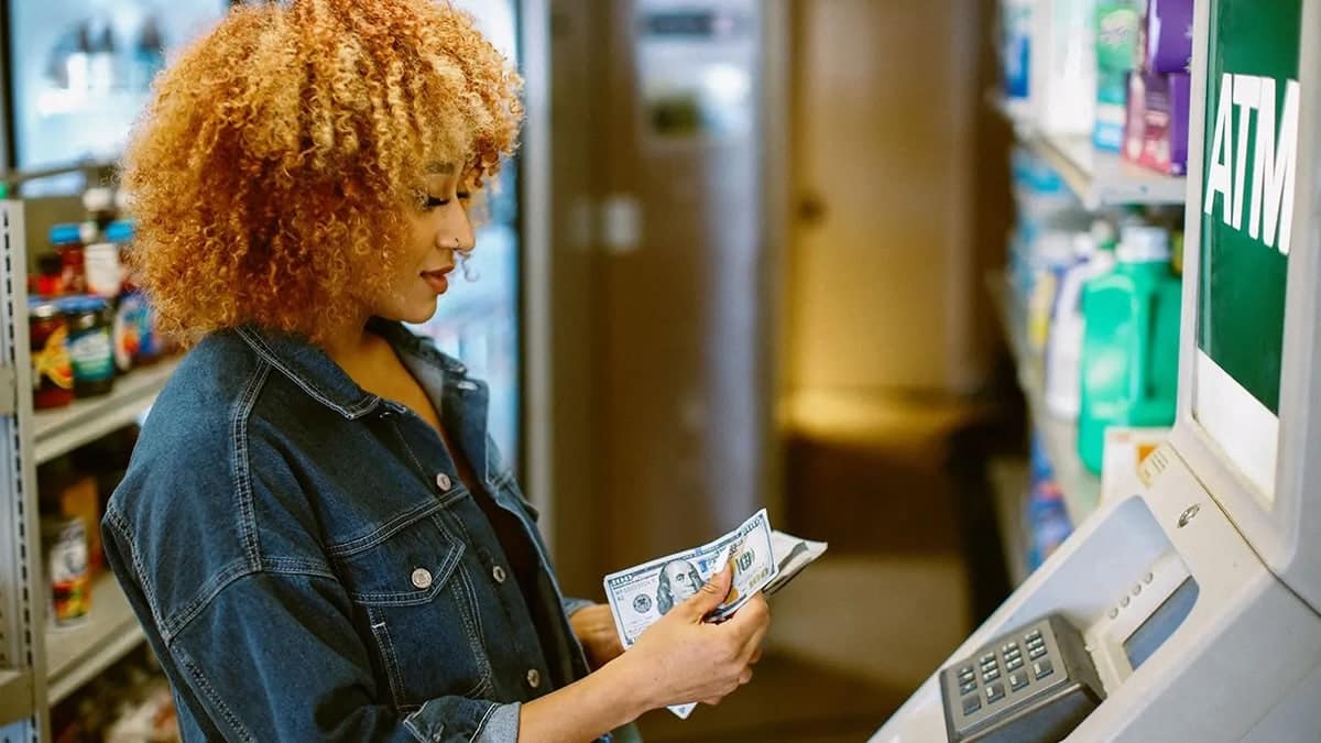 Lady grabbing cash at ATM machine