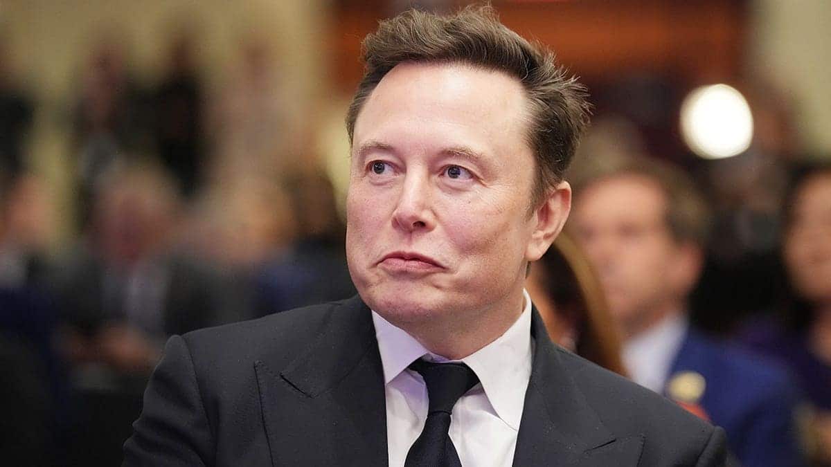 Elon Musk listens as Donald Trump speaks at a House Republicans Conference meeting.