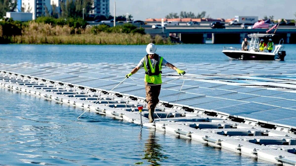 A technician works on floating solar panels.
