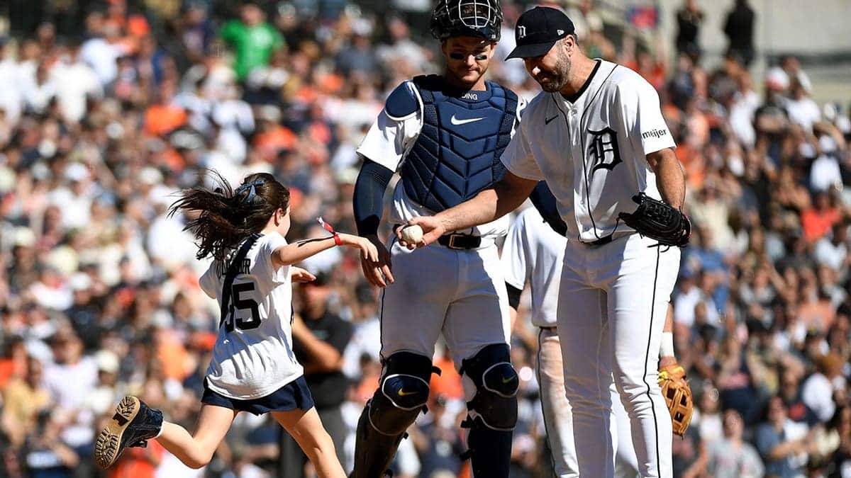 Genevieve Verlander runs to hug her father, Detroit Tigers pitcher Justin Verlander, as catcher Dillon Dingler looks on.