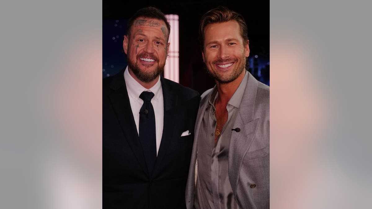 Jelly Roll and Glen Powell pose together on set.
