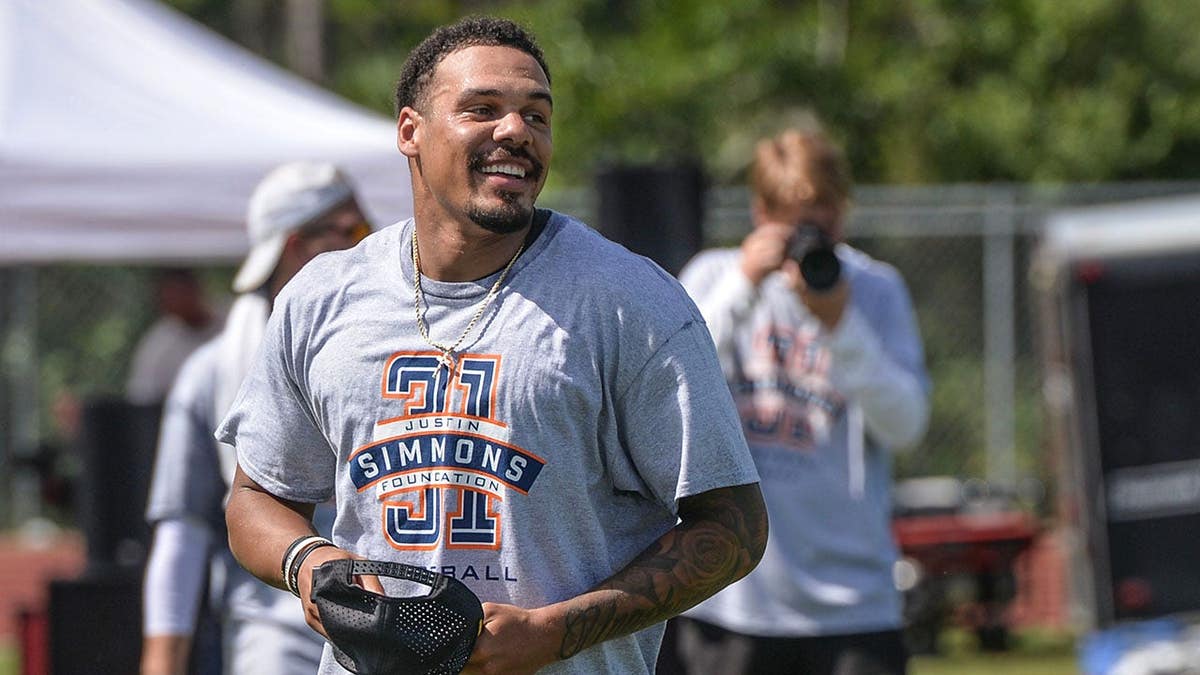 Justin Simmons stands with children at a youth football camp at South Fork High School.