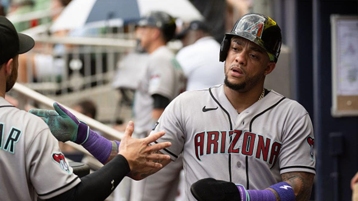 Ketel Marte #4 of the Arizona Diamondbacks returns to the dugout after scoring.