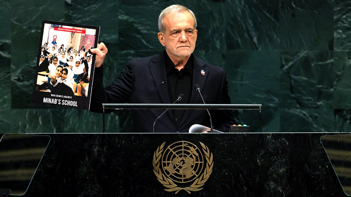 Masoud Pezeshkian holds up a photo that reads