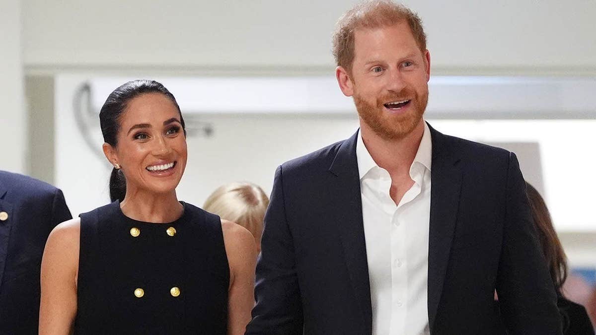 Meghan, Duchess of Sussex and Prince Harry stand during a hospital visit in Melbourne, Australia.
