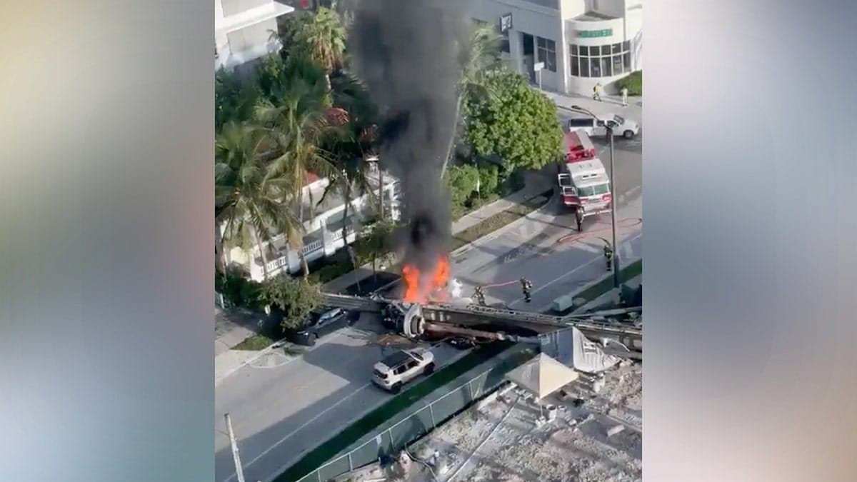 Four people were taken to the hospital Monday after a construction rig toppled onto three vehicles and a construction container in Miami, trapping two workers and igniting a vehicle fire, authorities said.