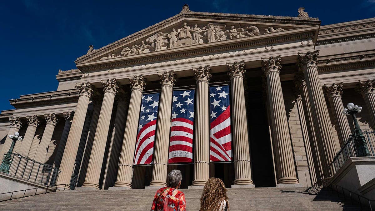 People stand in front of the National Archives Museum in Washington, D.C.