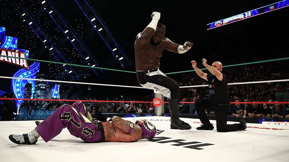 Omos elbow drops Rey Mysterio in the ring at MGM Grand Garden Arena.