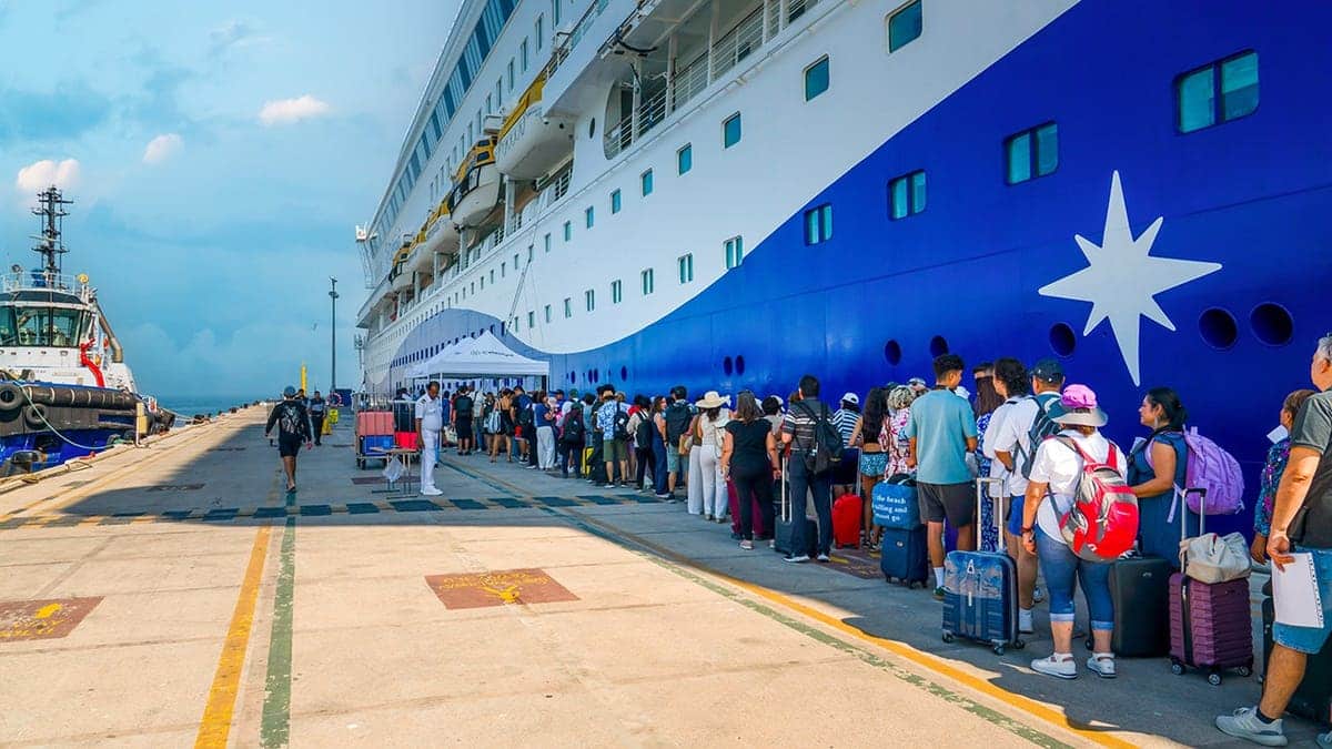 Long line of passengers boarding a large cruise ship at Ege Ports terminal in Kusadasi, Turkey.