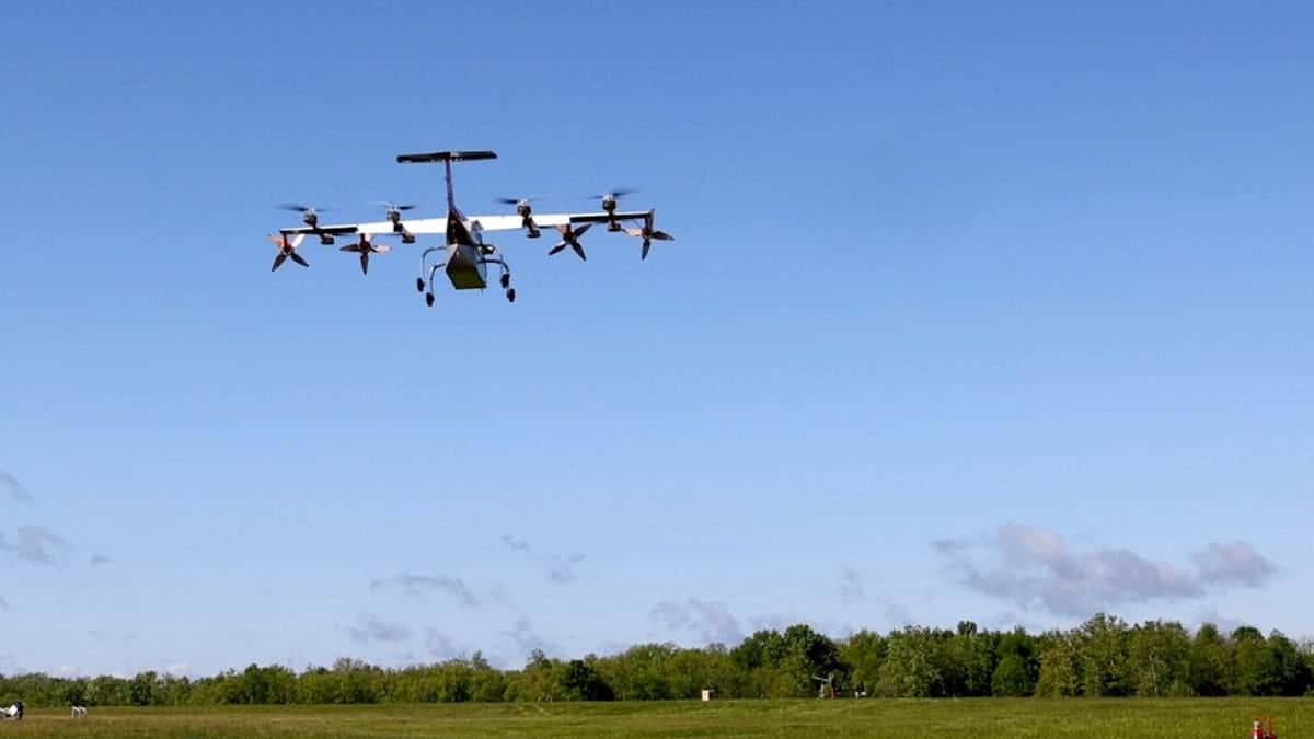 A pilotless cargo plane flies above a field.