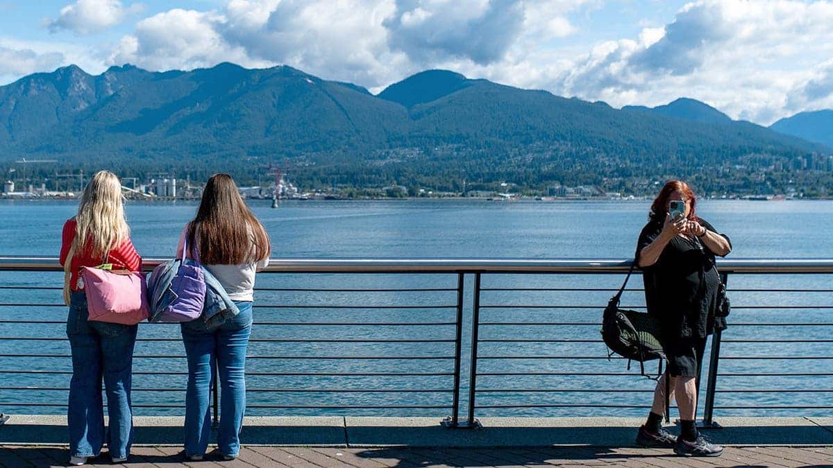 Passengers stand on a ship's deck in Vancouver.