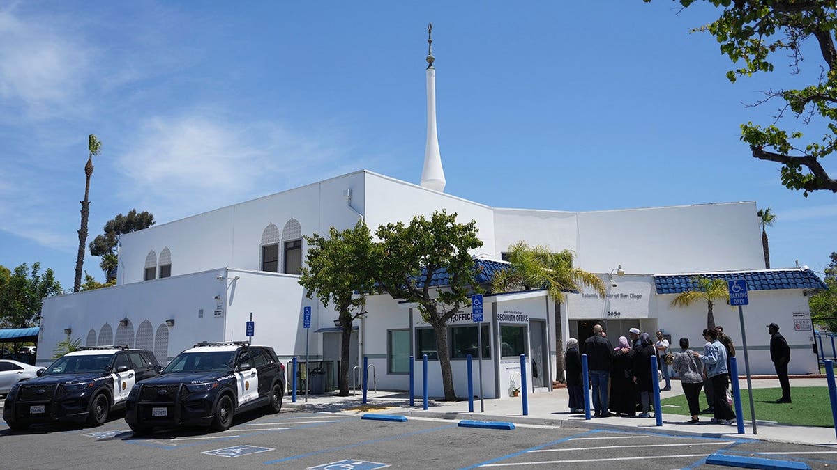 People gather near police vehicles outside the Islamic Center of San Diego.