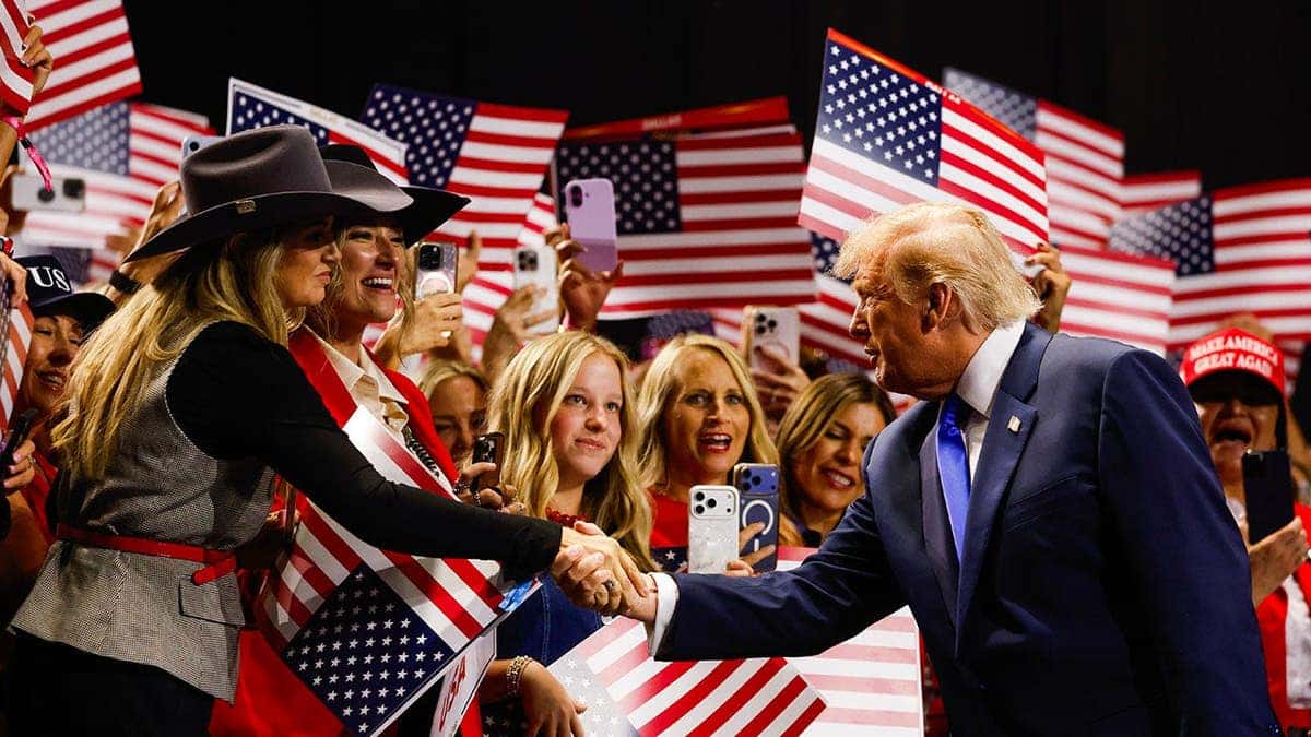 Donald Trump greets attendees while walking on stage at the American Airlines Center in Dallas, Texas.