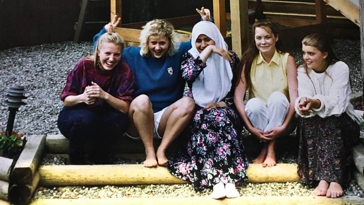 teenage girls sit on stoop outdoors laughing