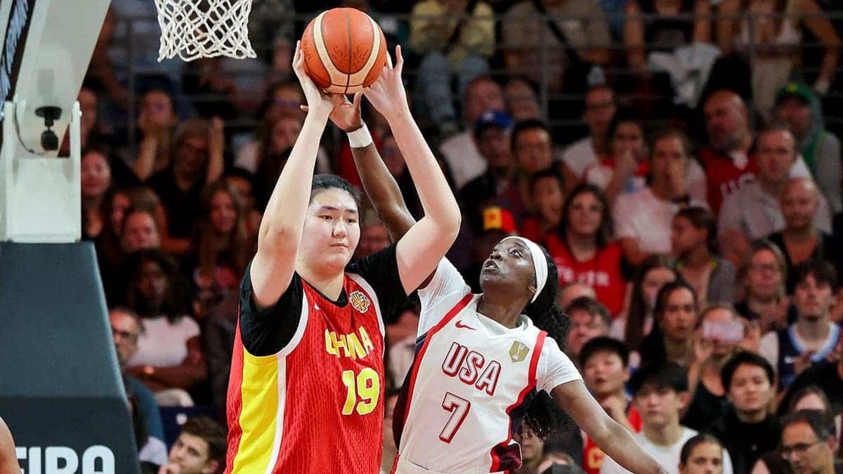 Ziyu Zhang of China and Kahleah Copper of USA battle for the ball during a basketball game.