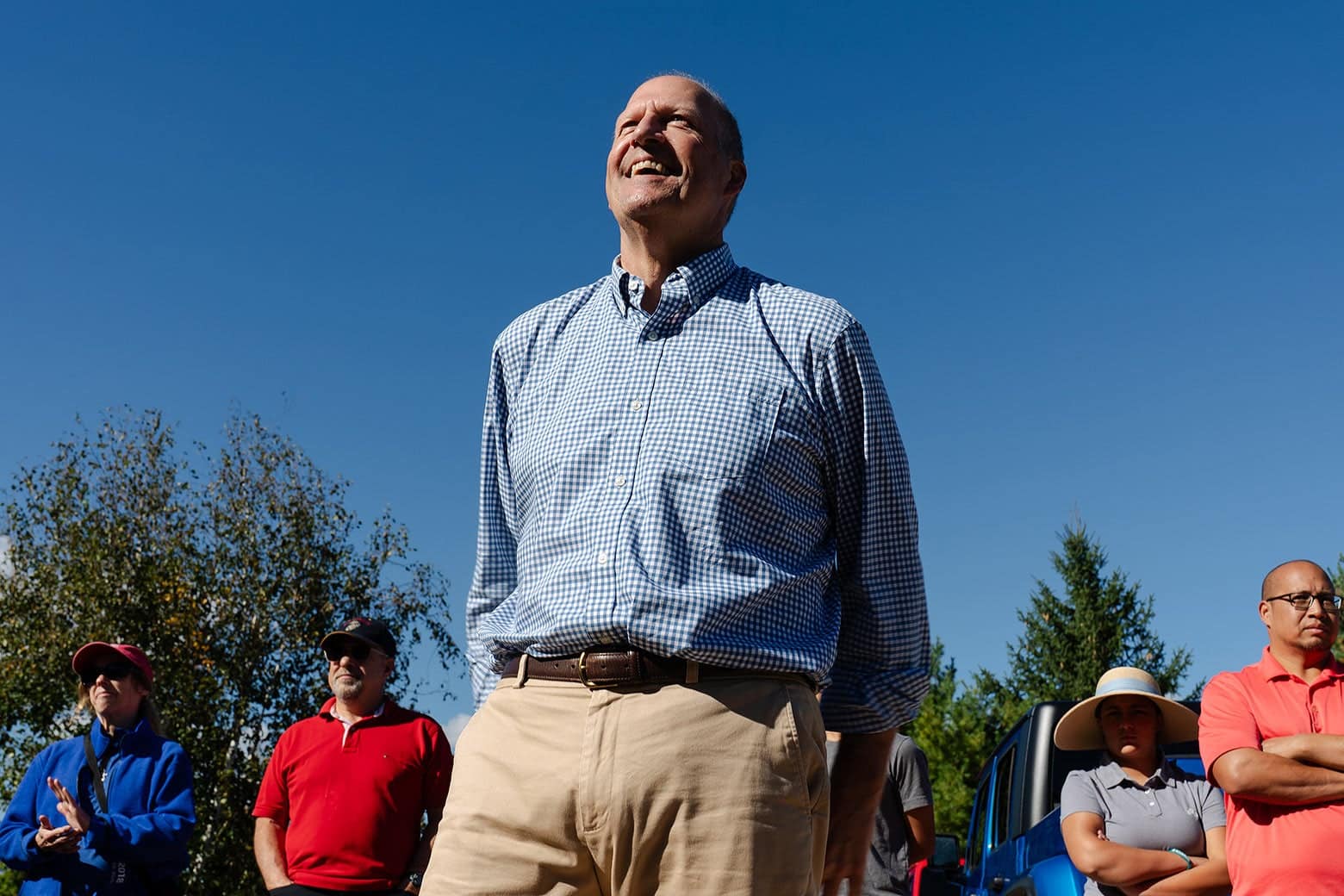 Sununu smiles broadly outside in the bright sun.