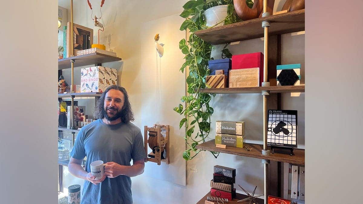 Art of Play co-owner Adam Rubin poses with Molly, a mechanical bird, inside the Brooklyn magic shop.