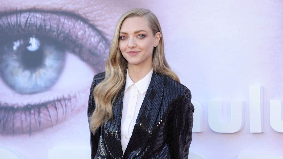 Amanda Seyfried posed in a black sequined blazer and white collared shirt with her blonde hair swept to one side at