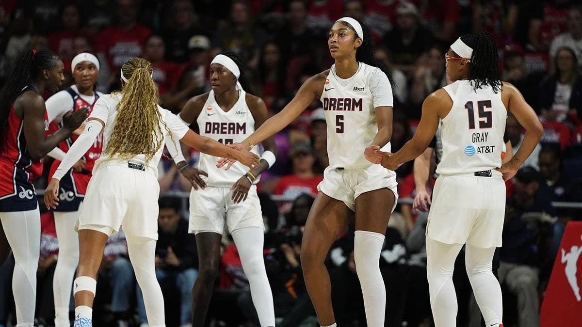 Angel Reese celebrating with teammates during a WNBA playoff game