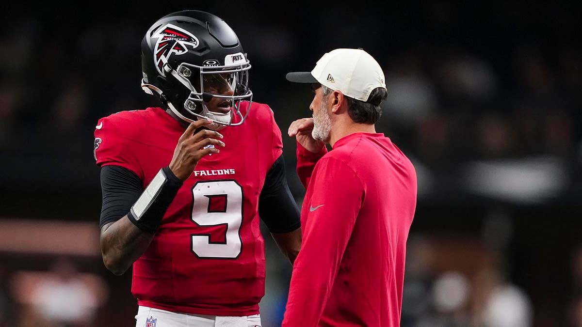 Michael Penix Jr. talks with Kevin Stefanski during an NFL game in New Orleans