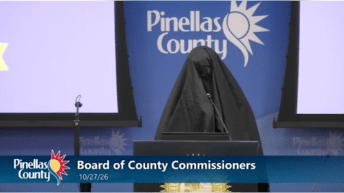 A woman in a veil speaks at the Pinellas County Board of County Commissioners meeting