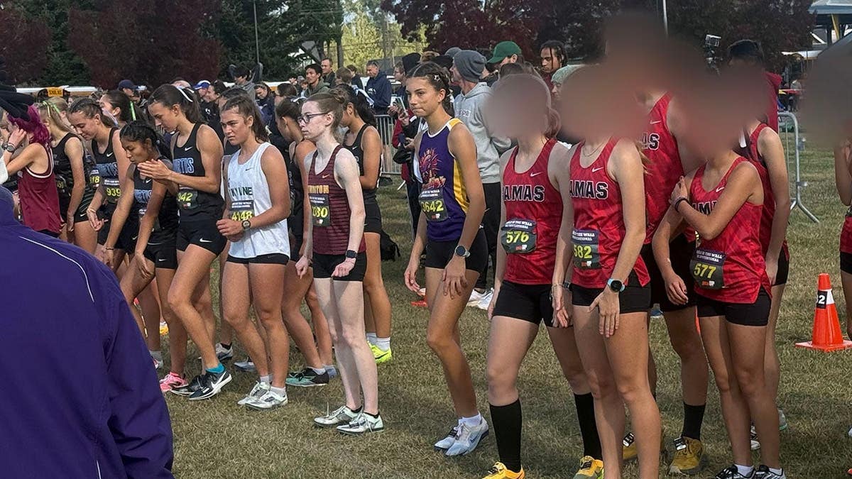 A Camas High cross country runner, who switched from the boys team to the girls team midseason, stands at the start line of a girls race in at the Nike Hole in the Wall XC Invitational.