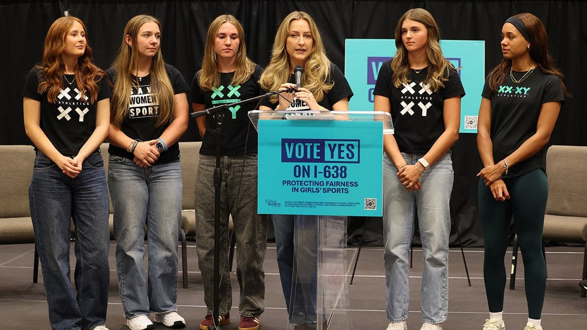 Female athletes gather on stage