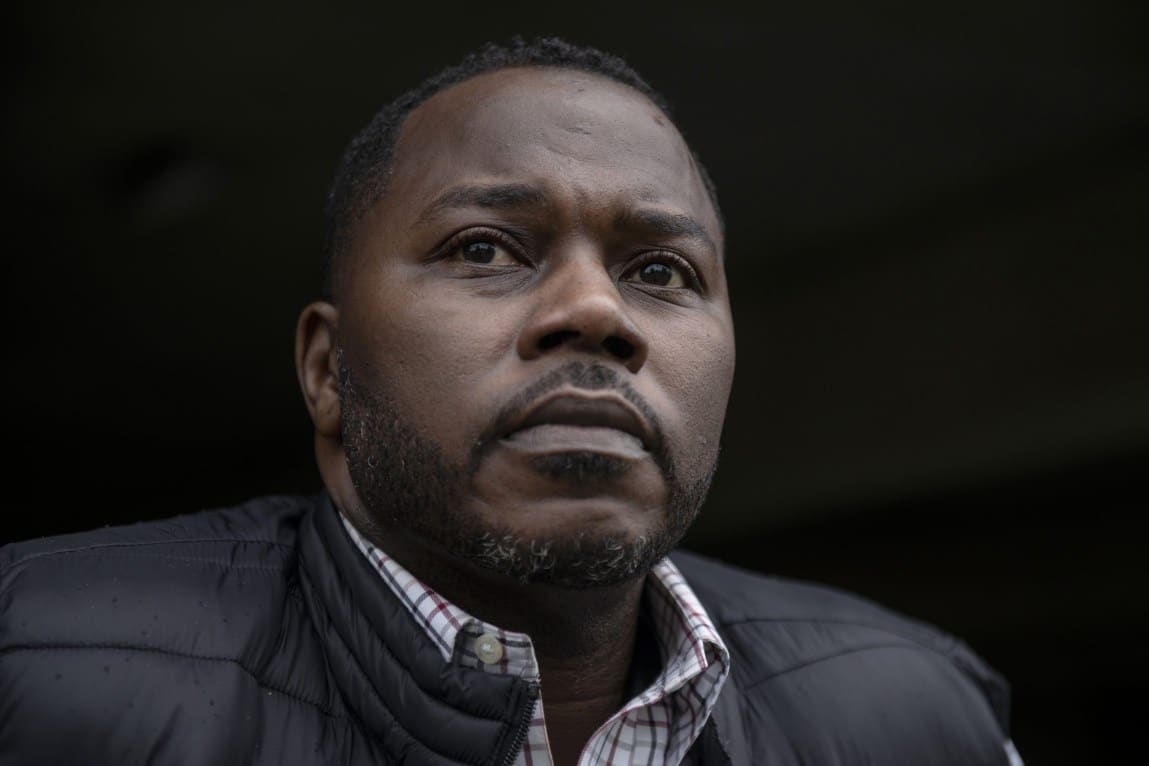 A close-up photo of a man with a serious expression.