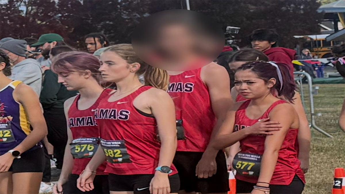 A Camas High cross country runner, who switched from the boys team to the girls team midseason, stands at the start line of a girls race in at the Nike Hole in the Wall XC Invitational.