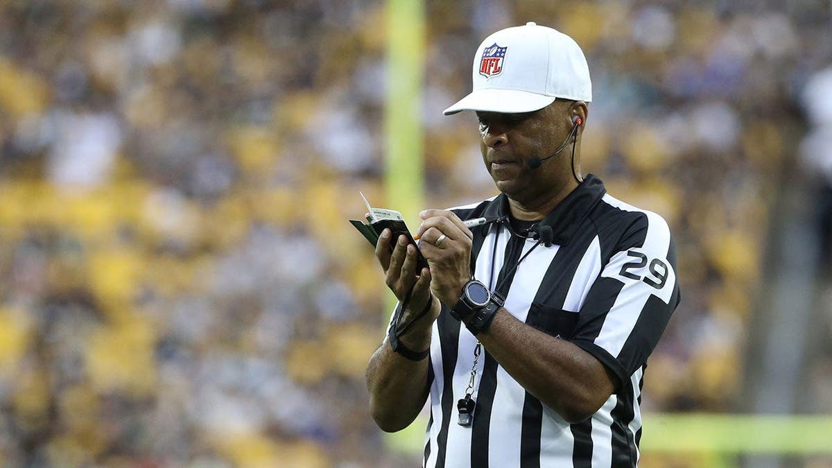 NFL referee Adrian Hill makes a note during the Seahawks-Steelers game at Acrisure Stadium.