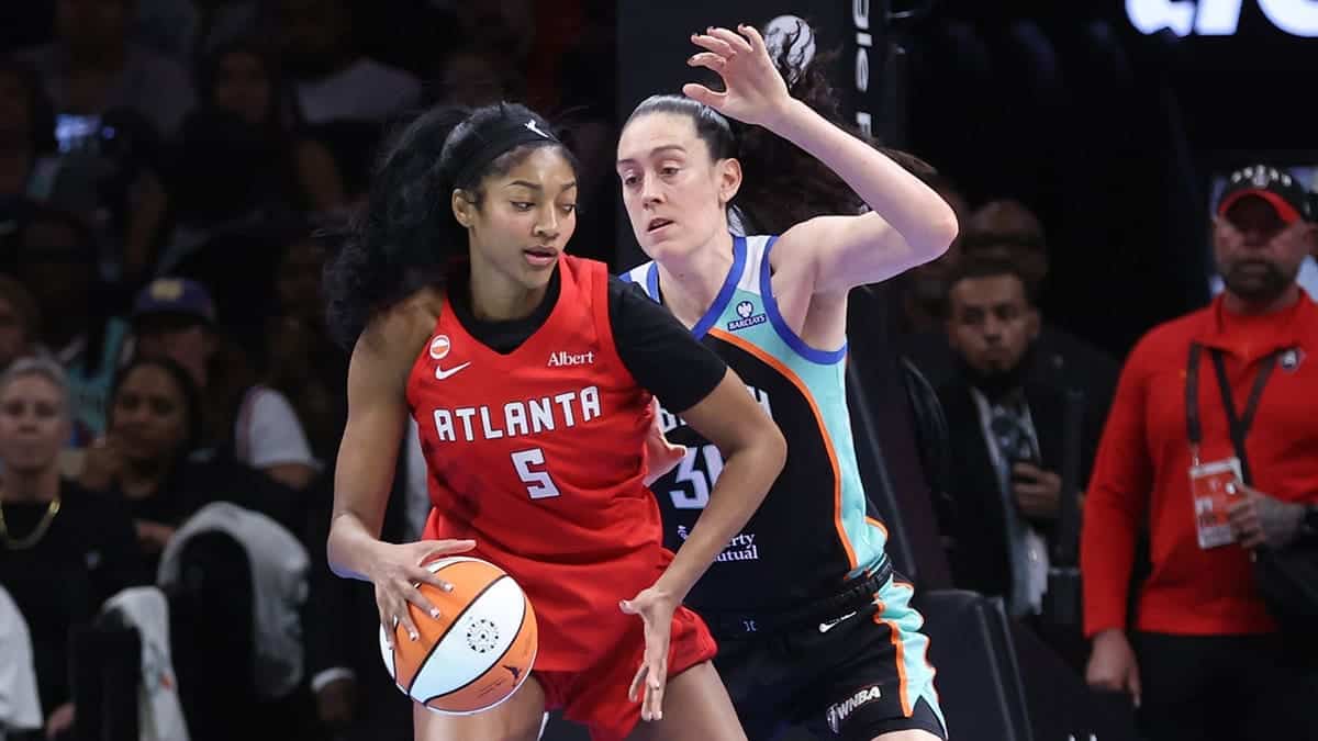 Angel Reese dribbles the basketball against Breanna Stewart during a WNBA playoff game.