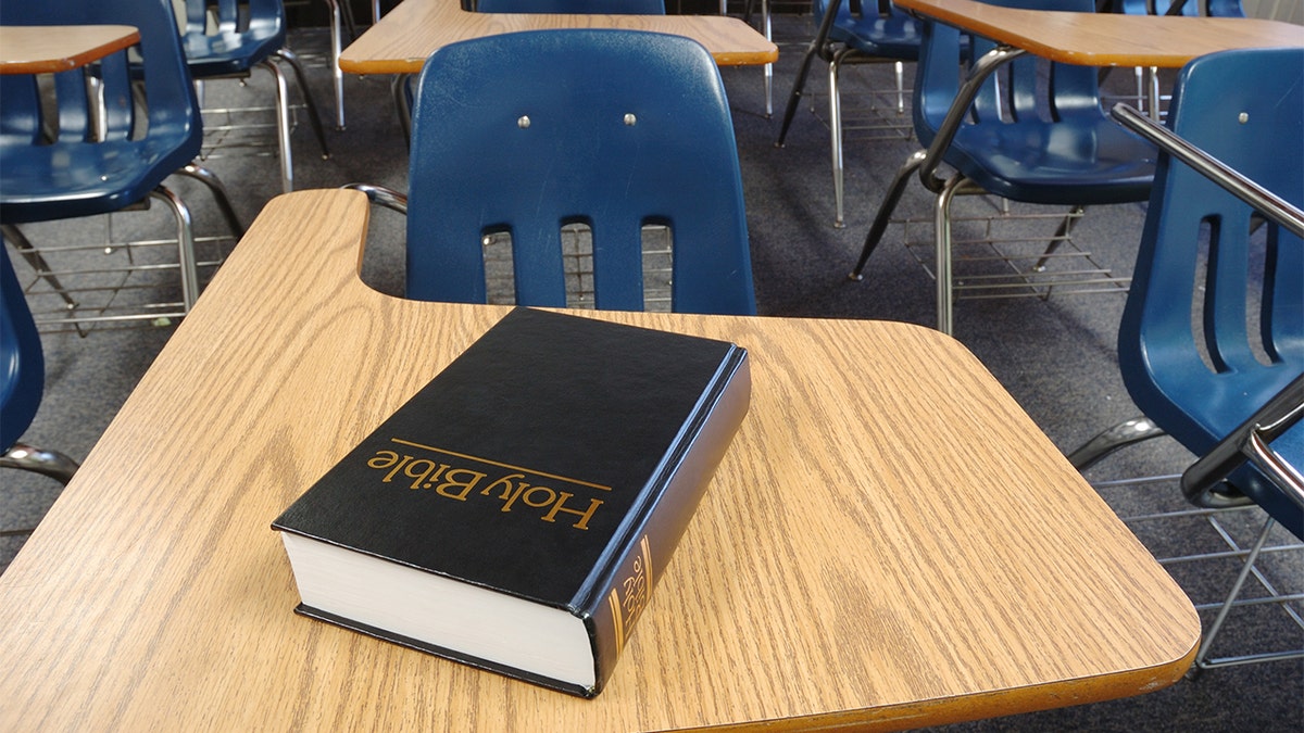 A bible is seen on a desk in a classroom