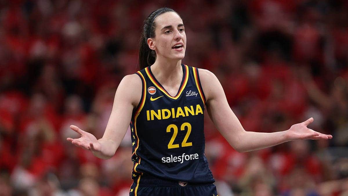 Caitlin Clark #22 reacts after being charged with a foul during an Indiana Fever WNBA Playoffs game.