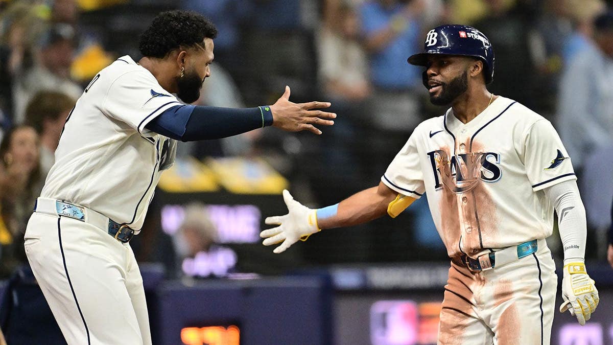 Cedric Mullins and Junior Caminero celebrate after hitting a home run at Tropicana Field.