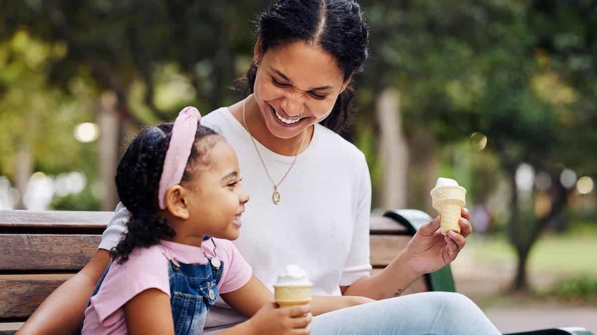 Child eating ice-cream with mother