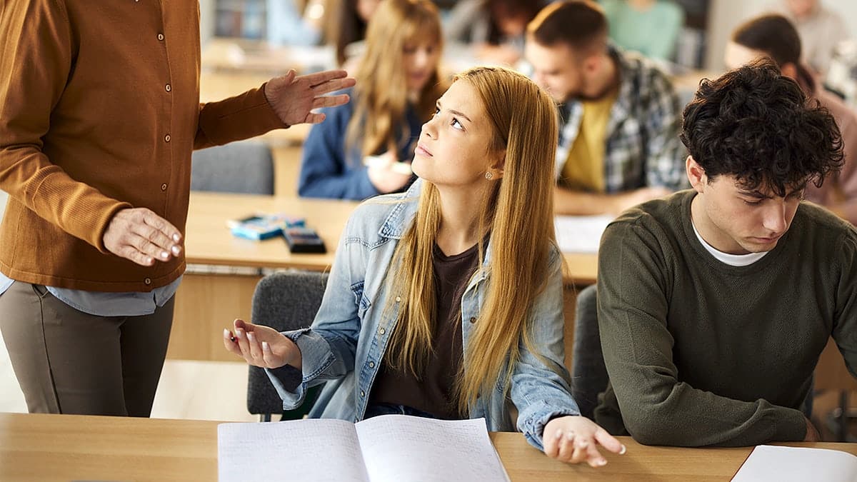 Student speaks with professor during classroom discussion.