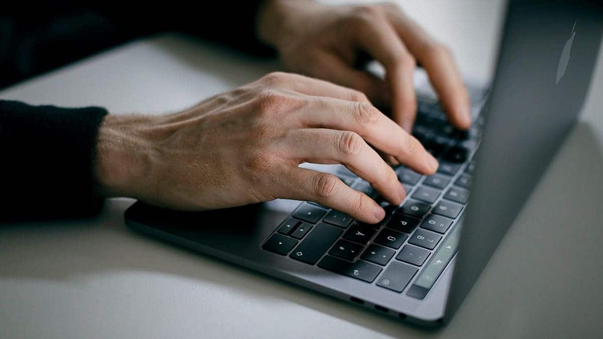 Man typing on his laptop.