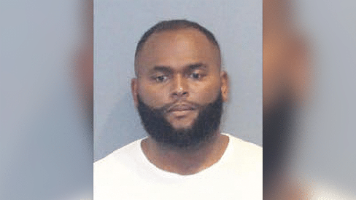 Edward Joseph Brown wearing a white T-shirt in his booking photo. He has a short-cropped haircut and beard.