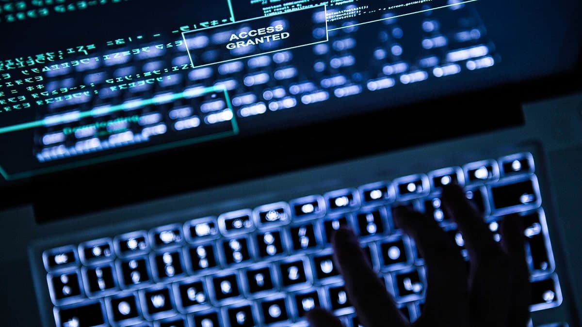 Hacker typing on a laptop.