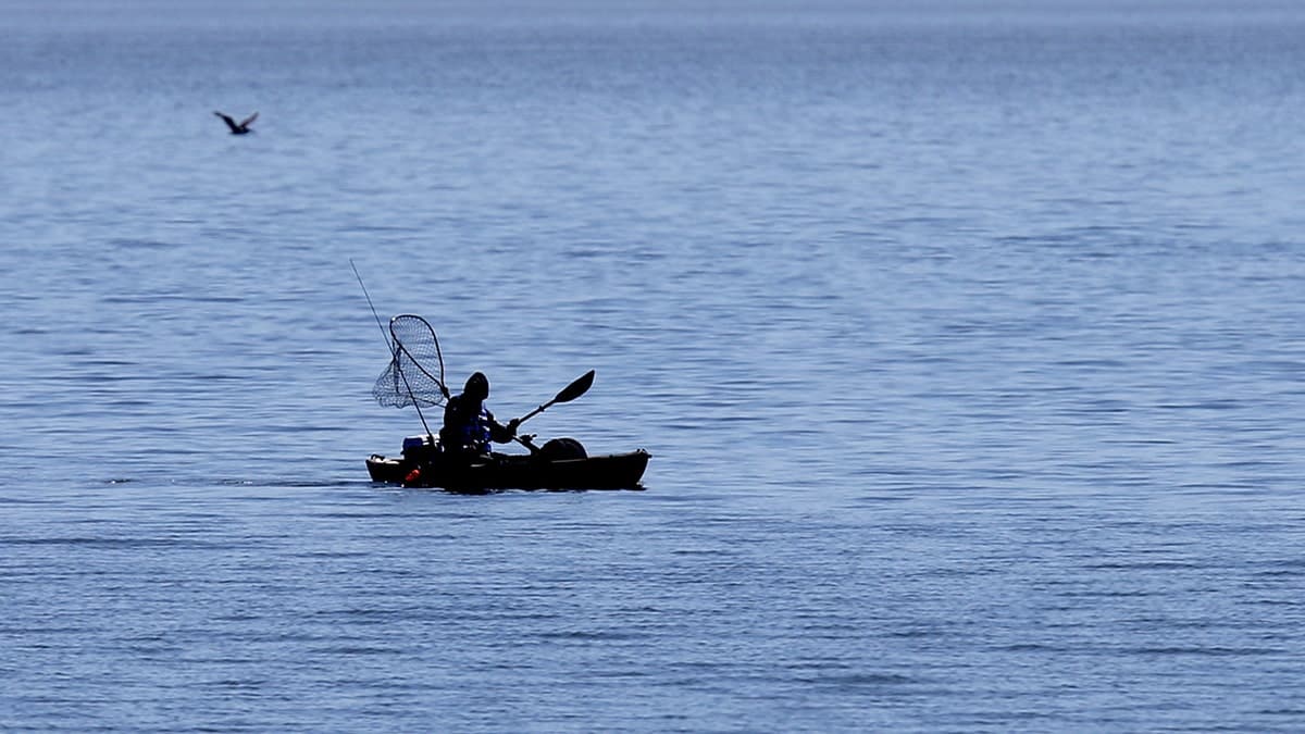 kayaker on beach fishing